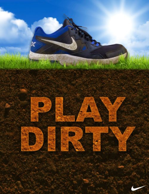 Tennis shoe on grass and dirt. The text in dirt says "PLAY DIRTY". The Nike check logo is visible in bottom right corner.