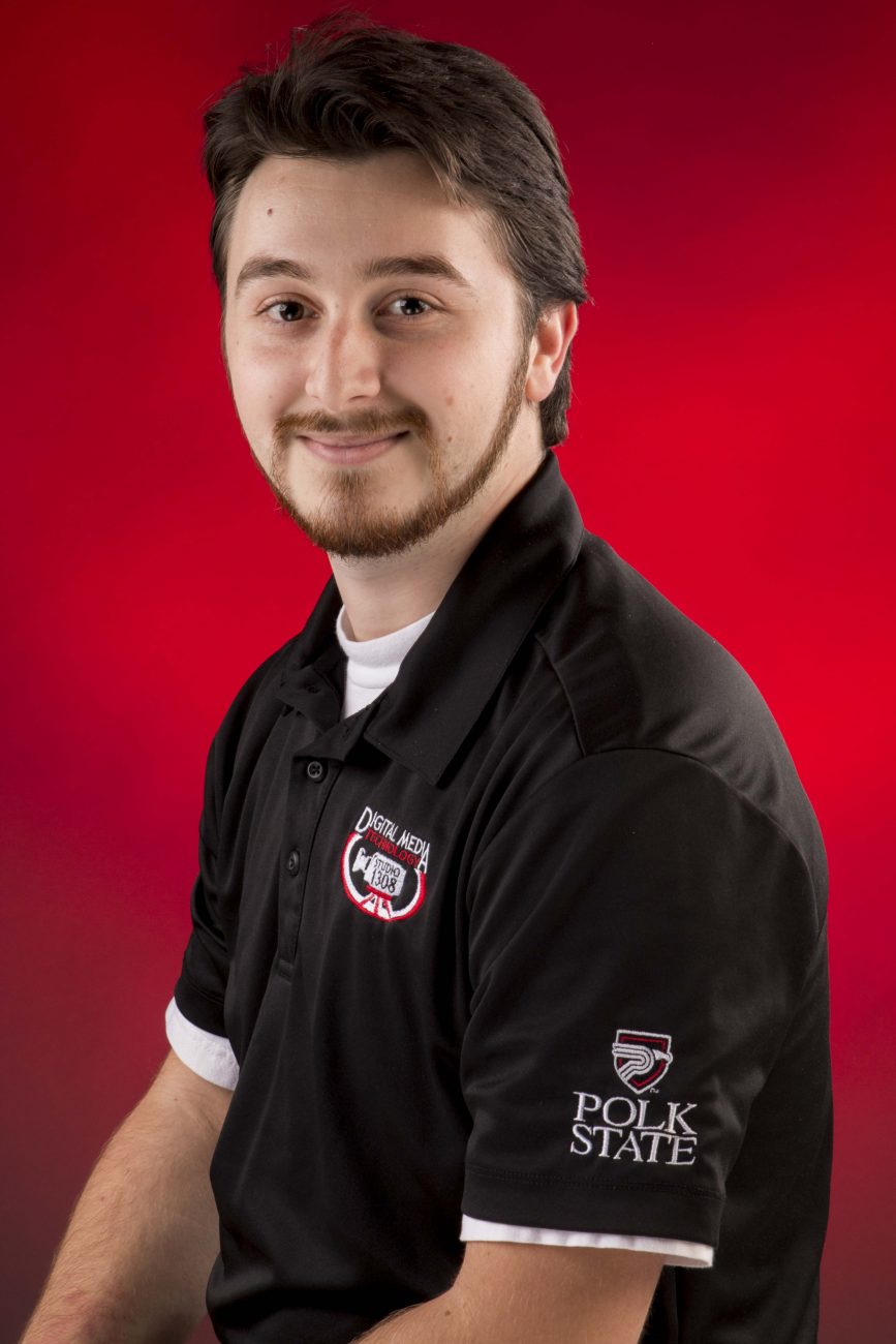 Portrait of Keith Nehila in the Digital Media Studio 1308 shirt against a red backdrop