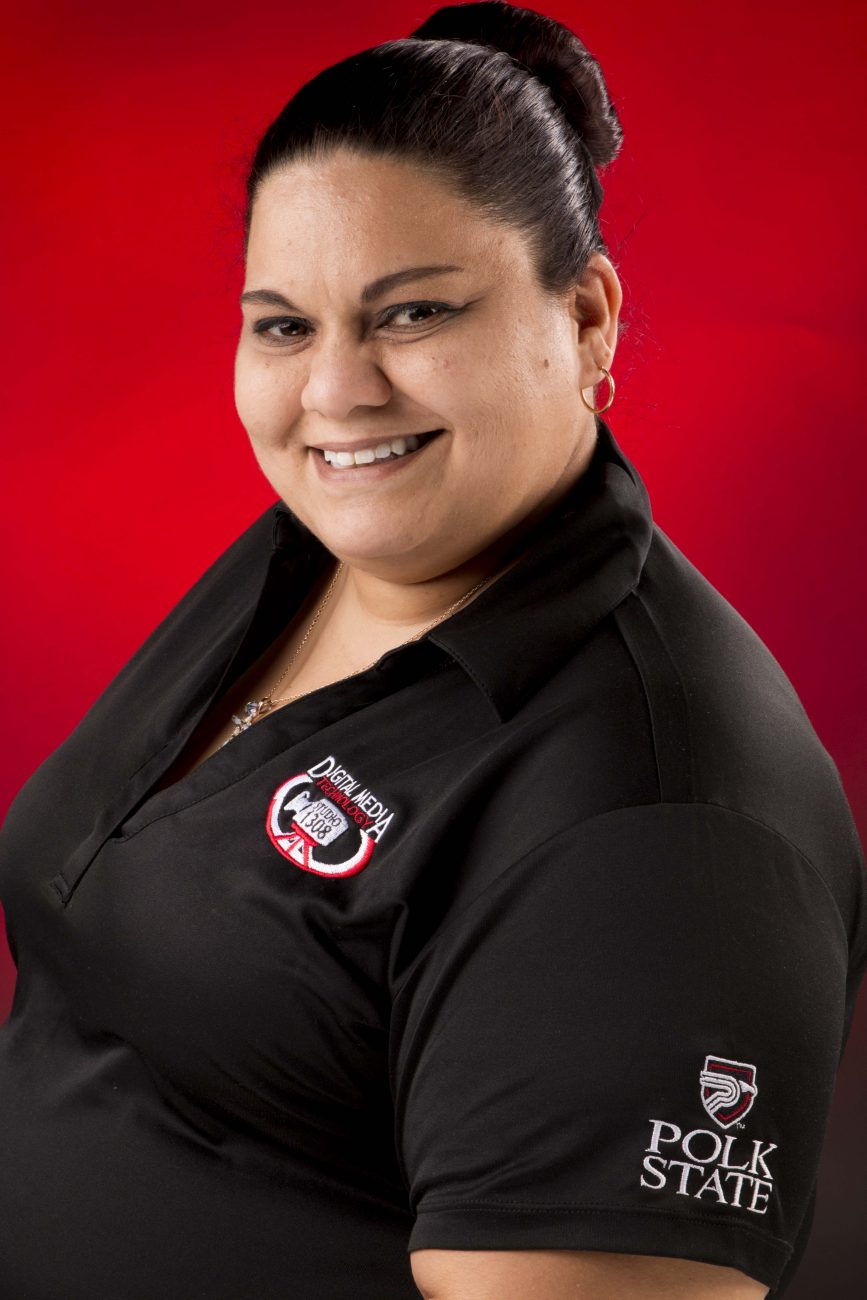 Portrait of Millie Lopez in the Digital Media Studio 1308 shirt against a red backdrop
