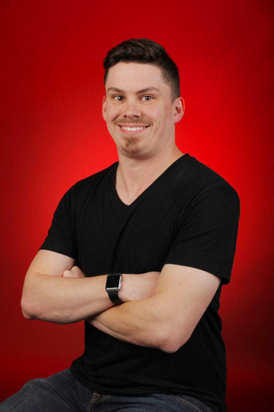 Portrait of Jotham Johnson in the Digital Media Studio 1308 shirt against a red backdrop