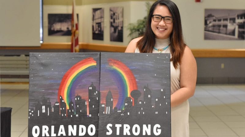 Polk State alumna Jenny Nguyen with her painting, "Orlando Strong."