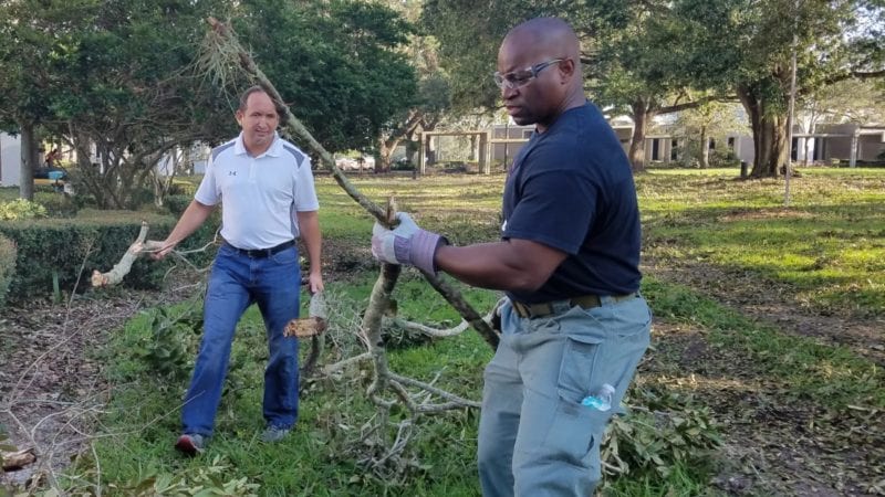 Robbie Manikis, Project Engineer and Lt. Bobby Neil, Security Coordinator, clear tree debris on Winter Haven Campus.