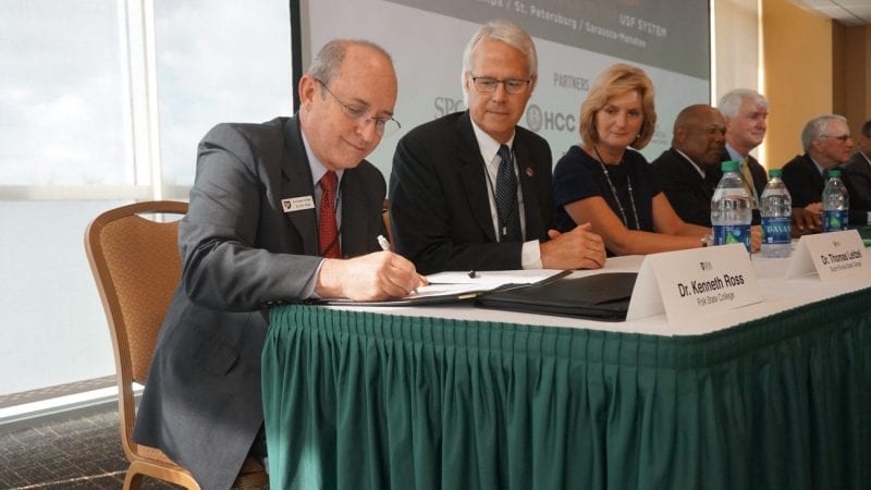 Polk State Vice President for Academic Affairs Kenneth Ross signs the FUSE agreement at USF Tampa on Friday alongside representatives from other FUSE partner institutions.