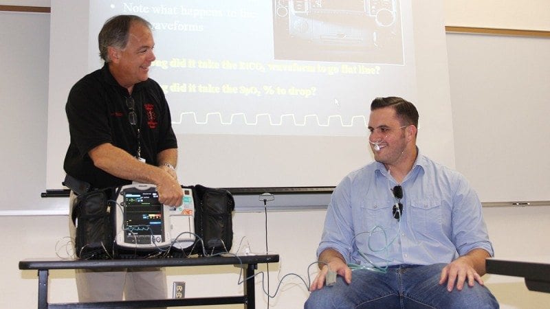 Polk State EMS Director Don Guillette (L) demonstrates nasal capnography on Derek McBrayer during Polk County Fire Rescue's EMS Week at Polk State Winter Haven.