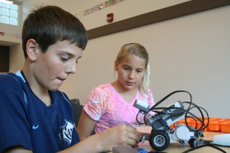 Seventh-graders Winston Allen and Grace Borst make adjustments to their robot.