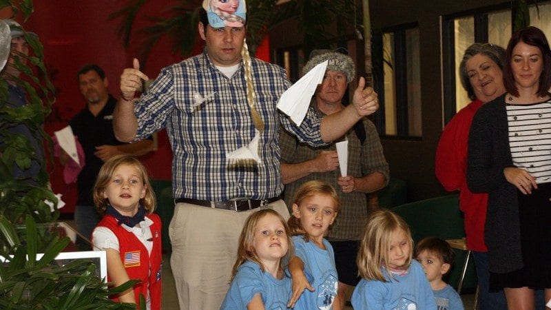 American Heritage Girls Troop 2101 visited Polk State's Aerospace program on Monday. During the field trip, members of the troop made paper airplanes and took turns in the program's flight simulators. Here, Program Director Eric Crump, wearing a cap featuring the Disney princess Elsa, leads the paper-airplane throwing contest. The winner of the contest got to wear the Elsa cap and take the first turn in the flight simulator.