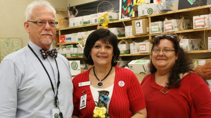 From left, Polk State Art Professor Gary Baker, Dean of Academic Affairs Martha Santiago, and student Laura Hawkins. Hawkins has multiple vision impairments but still pursues her interest in art. She recently presented Santiago with a vase she made in Baker's class.