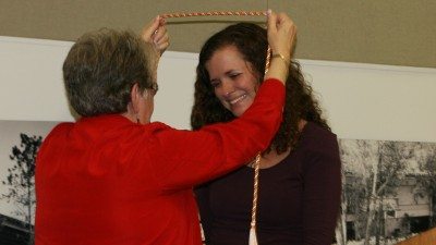 Polk State Nursing Director Annette Hutcherson places a cord around the neck of student Alison Richards, a symbol of her induction into Alpha Delta Nu, the national honor society of associate-degree-level nurses. The College held its first induction ceremony for its chapter of Alpha Delta Nu on Monday. Sen. Denise Grimsley, an alumna of the Nursing program, spoke at the ceremony.