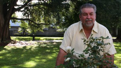 Polk State Athletic Director Bing Tyus is also a successful gardener. Here, he shows off two rose bushes he grew from clippings off other bushes in his yard.