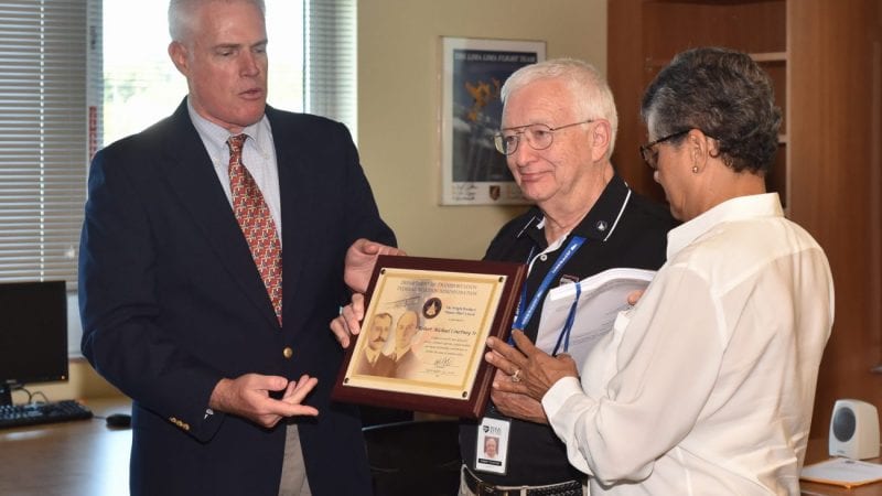 Polk State Aerospace Program Coordinator Mike Courtney, center, receives the FAA's Wright Brothers Master Pilot Award from the FAA's Robert Jex with his wife Doris by his side.