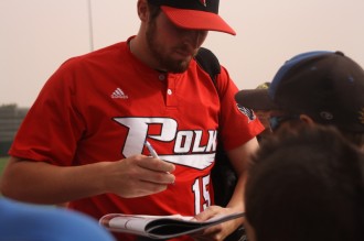 Polk State Pitcher Alec Asher signs autographs after the Eagles win in the first round of the NJCAA JuCo World Series.