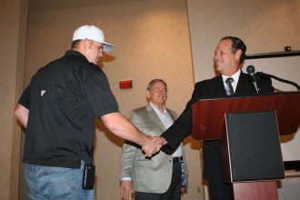 Josh Kelly (L) receives a certificate for completing the Polk State Corporate College Mosaic Apprenticeship Program from Mosaic training specialist Rick Johnson during a Friday luncheon. Bob Latchford, Polk State adjunct for the program, looks on. Kelley is applying the credits he earned through the program toward the College's associate degree in Engineering Technology.