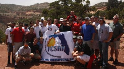 Polk State Baseball players, coaches and others traveling with them in Grand Junction, Colo., display the team's state championship banner at Colorado National Monument on Friday.