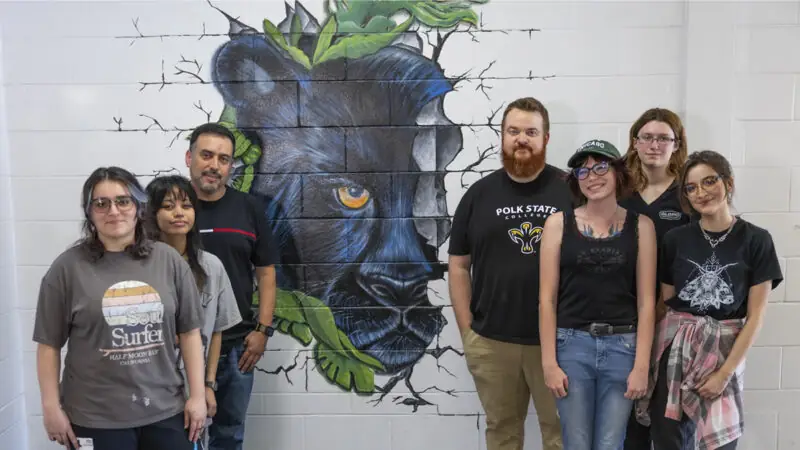 Art students and faculty in front of mural at Denison Middle