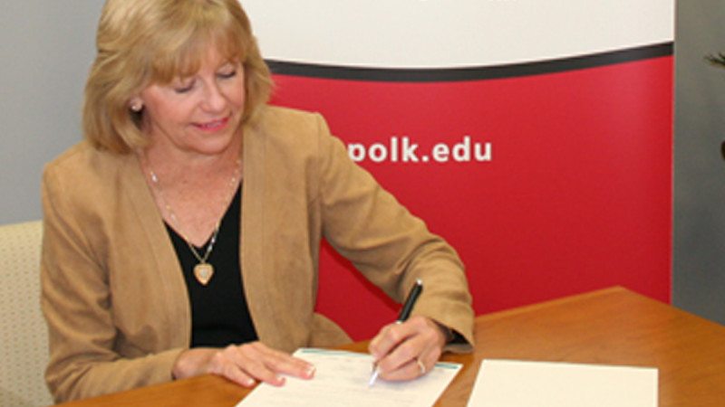 Polk State President Eileen Holden adds her signature to the Graduate Polk initiative, a Polk Vision education initiative to help area residents complete their college degrees.