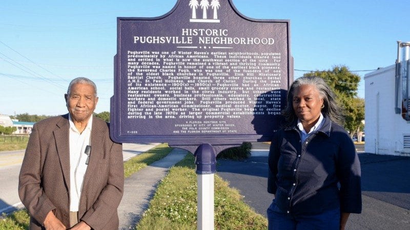 Lemuel Geathers and Patricia Smith-Fields, natives of Pughsville, stand near a historical marker for their neighborhood. The rezoning of Pughsville in the 1960s helped bring Polk State to Winter Haven.