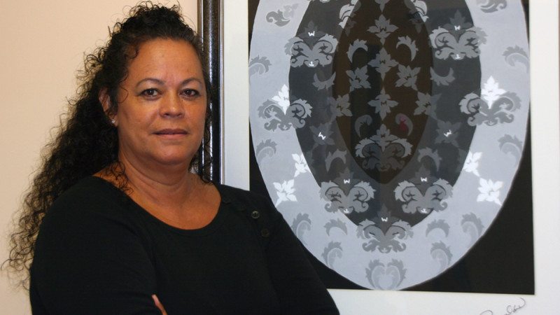 Polk State student June Reynolds with her as-yet-unnamed painting, which hangs in the office of Veterans Services Coordinator Carole Shelton-Toney.