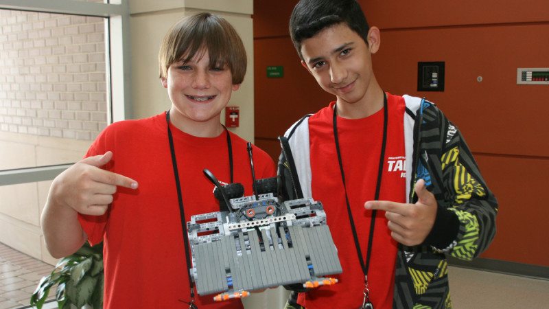 Carson Warner (L) and Michael Jenkins won first place in the sumo competition at Thursday's Robot Rumble. Warner and Jenkins said adding claws to the front of their machine was key to securing the victory.